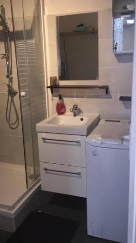 a white bathroom with a sink and a shower at Latitude - Appartement proche Notre Dame de la Garde in Marseille