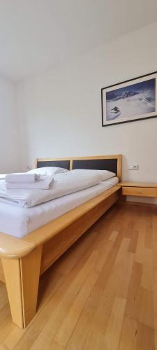 1 dormitorio con cama de madera en una habitación en Four Seasons Getaway - 3 minutes From Town Centre, en Zell am See