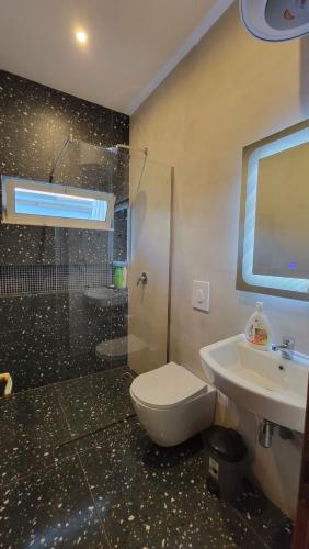 a bathroom with a shower and a toilet and a sink at Cozy villa, Golem beach. in Golem