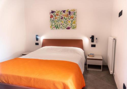 sypialnia z łóżkiem i obrazem na ścianie w obiekcie Corte Masnate - Arancio w mieście Lenno