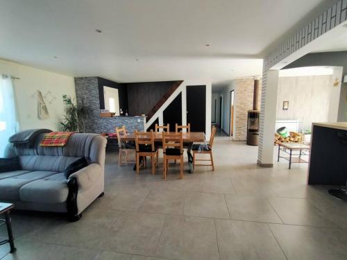 un salon avec un canapé et une salle à manger dans l'établissement Maison à 15 minutes de la Baie de Somme, à Friville-Escarbotin