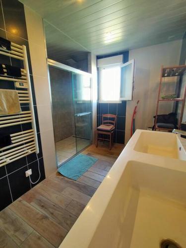 La salle de bains est pourvue d'une grande baignoire et d'une douche. dans l'établissement Maison à 15 minutes de la Baie de Somme, à Friville-Escarbotin