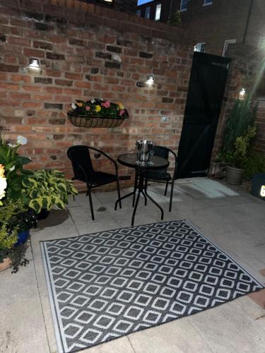 patio con mesa, sillas y pared de ladrillo en The Hideaway en Chester
