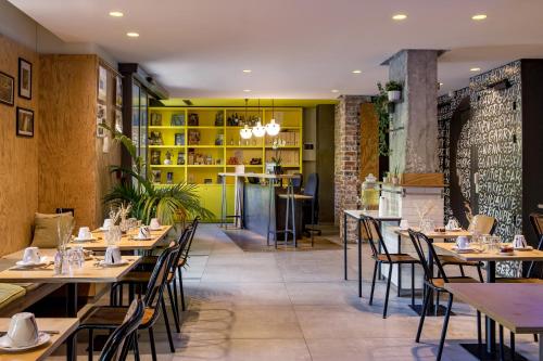 een restaurant met tafels en stoelen in een kamer bij Hôtel Gaston in Parijs