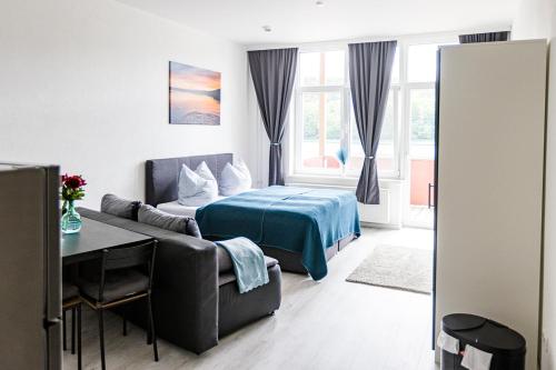ein Schlafzimmer mit einem Bett und einem Sofa in einem Zimmer in der Unterkunft Ferienwohnungen direkt am Werbellinsee in Joachimsthal