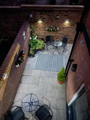 a patio with a table and chairs and a brick wall at The Hideaway in Chester