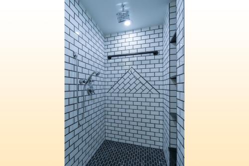 a bathroom with a shower with white tiles at Bear Claw 104 - Bear Claw I Building in Steamboat Springs