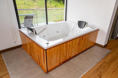 a large bath tub in a room with a window at Guayupes Hotel de Aventura in Guamal