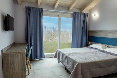 ein Schlafzimmer mit einem Bett und einem großen Fenster in der Unterkunft Ca' Brichella in Cairo Montenotte