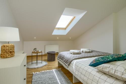a attic bedroom with a bed and a skylight at Apartament Abra 1 Rynek 8 in Muszyna