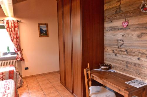 Habitación con pared de madera y mesa de madera. en Appartamenti Luseney en Bionaz