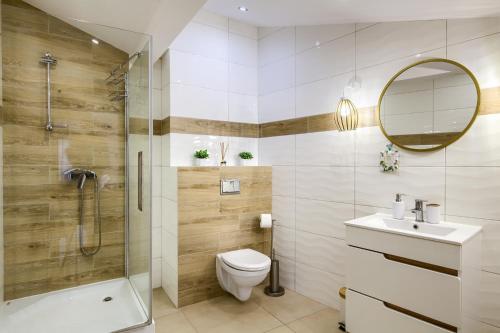 uma casa de banho com um chuveiro, um WC e um lavatório. em Apartament Abra 1 Rynek 8 em Muszyna