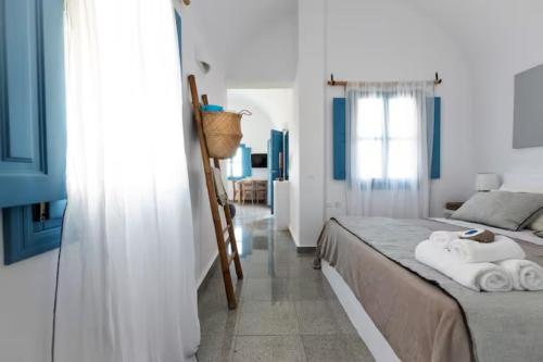 a bedroom with a bed with towels on it at GTK Santorini Oia Sunset Villas in Thólos