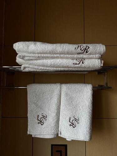 un gruppo di asciugamani su una mensola in bagno di Hotel Rion a Mangalia