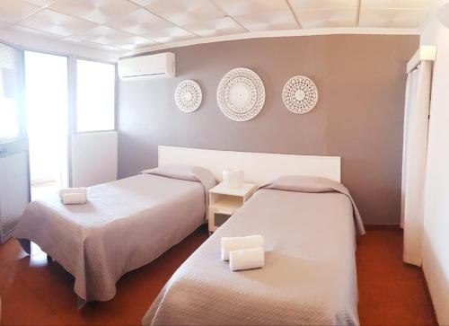 Pokój z dwoma łóżkami i dwoma talerzami na ścianie w obiekcie Alcamim Guesthouse w mieście Elvas