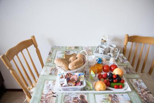 a table with a breakfast of bread and fruit on it at B&B Molenaar in Buren