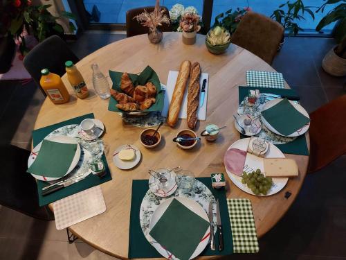 a wooden table with plates of food on it at La Clé du Circuit Spa-Francorchamps in Stavelot