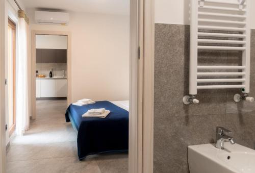 レンノにあるCorte Masnate - Blueのベッド1台、バスルーム(シンク付)が備わります。