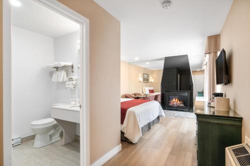 a hotel room with a bed and a fireplace at Hotel Bromont in Bromont