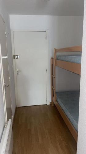 Cette chambre comprend 2 lits superposés et une porte. dans l'établissement Magnifique studio en bord de mer, à Calvi