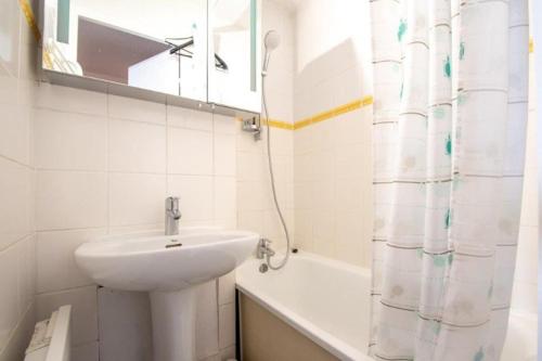 a white bathroom with a sink and a shower curtain at Studio Cabine 4 pers Les2Alpes 21m² in Les Deux Alpes