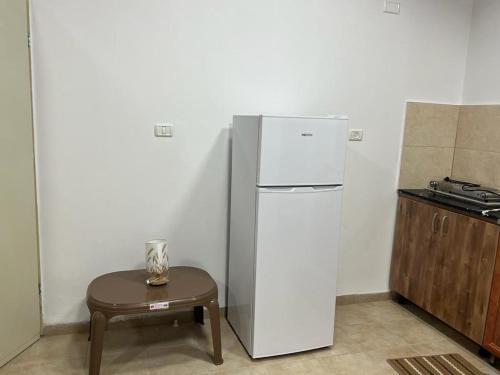 a white refrigerator in a kitchen with a table at Aida Magic of Nazareth - Guesthouse in Nazareth