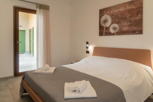 a bedroom with a bed with two towels on it at Corte Masnate - Grigio in Lenno