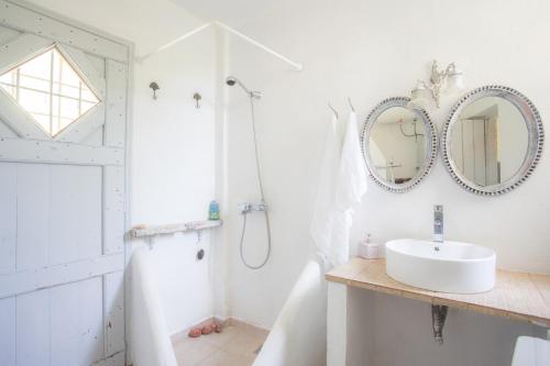 a white bathroom with a sink and mirror at Traditional family villa southern lefkada in Sívros