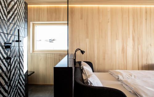 a bedroom with a bed and a desk and a window at HOLZGAUER HAUS in Warth am Arlberg