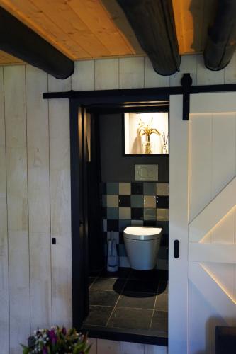 W pokoju znajduje się łazienka z białą toaletą. w obiekcie Vakantiehuisje Tol Oost w mieście Werkendam
