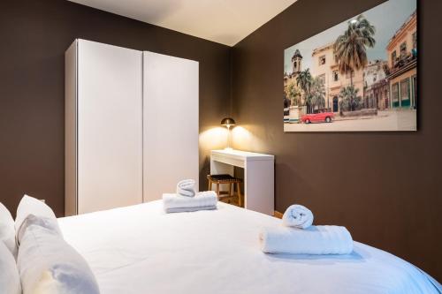 a bedroom with a white bed with towels on it at Brussels centre Bnb Sablon I, II et V in Brussels