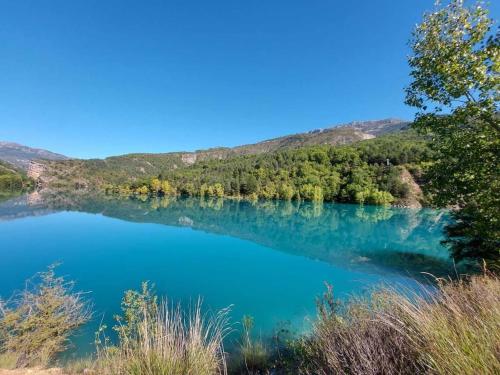 Una vista de un lago con árboles al fondo. en Large cozy studio in Castellane /Gorges du Verdon, en Castellane
