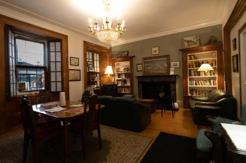 a living room with a table and a chandelier at Pring Guesthouse in Hamilton