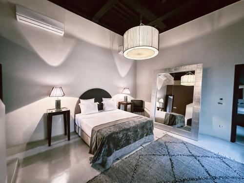 una camera da letto con un letto e un grande specchio di Riad K a Marrakech