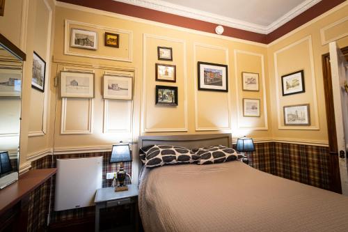 a bedroom with a bed and some pictures on the wall at Pring Guesthouse in Hamilton