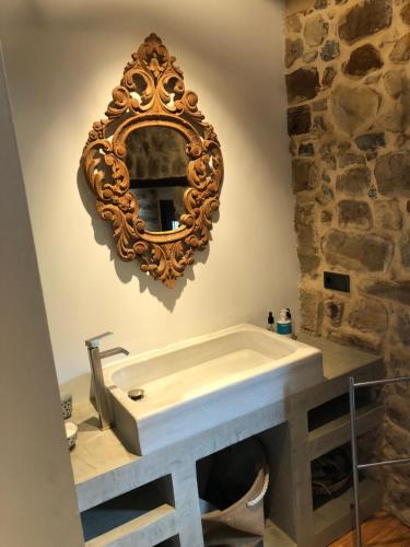 uma casa de banho com um lavatório e um espelho na parede em LA COROLLA em Villaviciosa