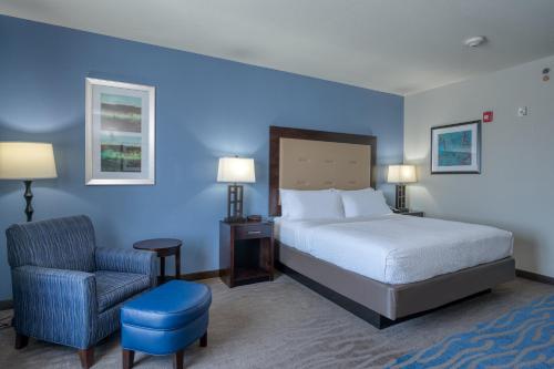 a hotel room with a bed and a chair at Holiday Inn Express and Suites Edwardsville by IHG in Edwardsville