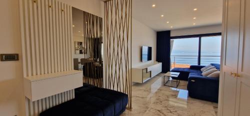 een woonkamer met een blauwe bank en een televisie bij Apartment Eclipse in Opatija