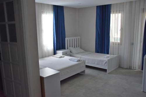 a small room with two beds and a window at La Sorella in Dalyan