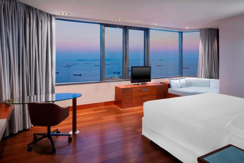 um quarto de hotel com uma cama, uma secretária e uma televisão em Sheraton Istanbul Atakoy Hotel em Istambul