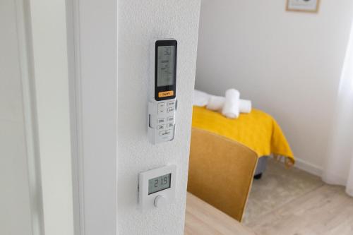 a remote control in a room with a bed at Rooms & Apartment Perak in Kutjevo