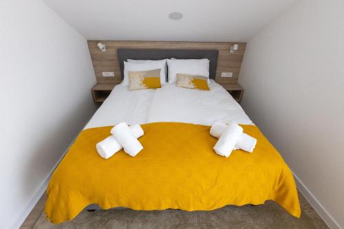 Kutjevo的住宿－Rooms & Apartment Perak，卧室配有一张带黄色毯子和枕头的大床