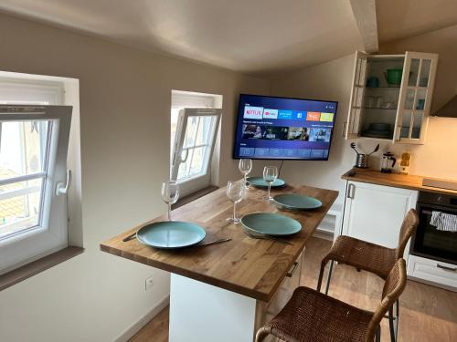 Il dispose d'une télévision et d'une cuisine avec une table et des verres à vin. dans l'établissement T1Bis Neuf Climatisé CentreVille #15, à Toulon