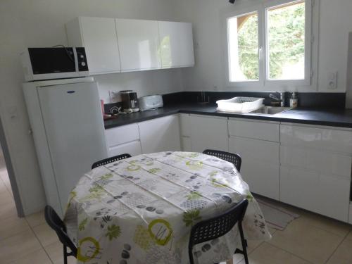 une cuisine avec une table recouverte d'une nappe dans l'établissement maison 3 classée étoiles à,proximité de Contis Plage, à Saint-Julien-en-Born