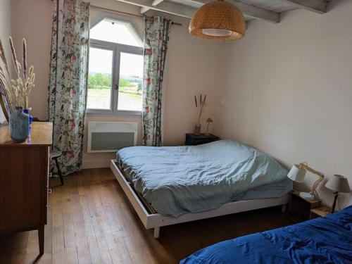 une chambre avec un lit et une fenêtre dans l'établissement Maison de campagne Mon repos, à Courpignac