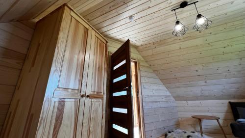 an attic room with a wooden door and lights at Śtyry Pory Roku in Bór Leśnica