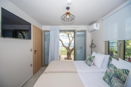 a bedroom with a large white bed and a window at Casa Spiaggia in Marathias