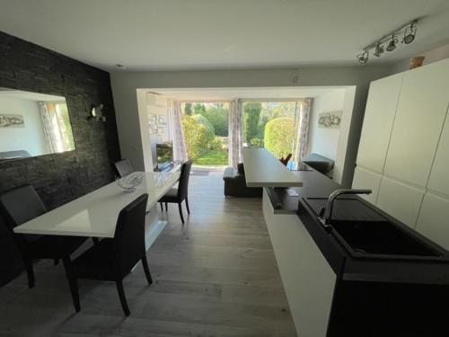 une cuisine et une salle à manger avec tables et chaises dans l'établissement Les Restanques Maison de la pinède 2 chambres, à Grimaud