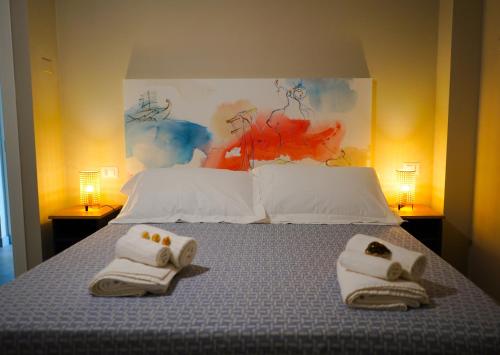 una camera da letto con un letto e asciugamani di Penelope a Porto SantʼElpidio