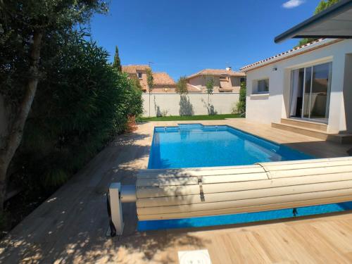 une piscine dans l'arrière-cour d'une maison dans l'établissement VILLA FLAVIE- Luxueuse - Confort Jardin Barcecue Borne Recharge Electrique 10min PLAGE- FAMILLE-PISCINE-TOP PROS SERVICES Conciergerie, à Lattes